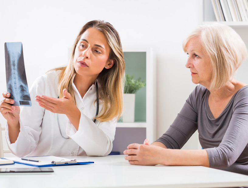 Doctor-showing-x-ray-scan-to-female-patient