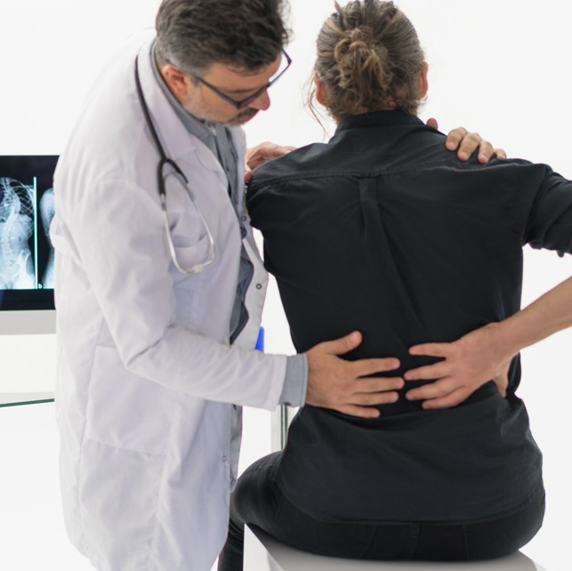 Doctor-speaking-to-patient-about-back-pain-in-clinic